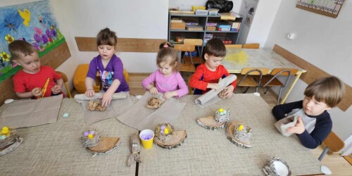 Dzieci  przy stoliku tworzą stroiki wielkanocne