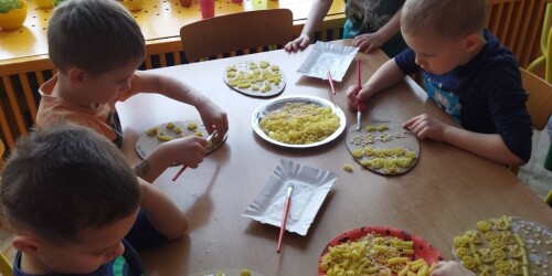 Dzieci układają różne kompozycje z makaronu na pisance