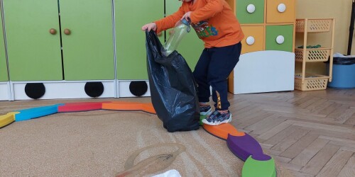 Chłopiec na ścieżce sensorycznej zbiera śmieci