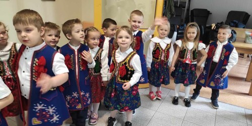 Dzieci stojące w parach w strojach krakowskich