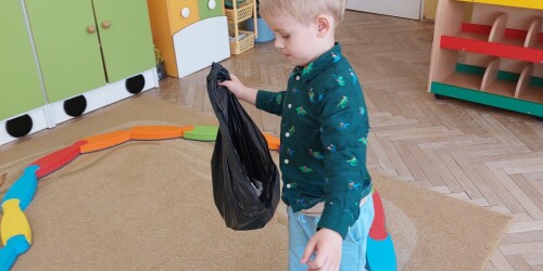 Chłopiec z workiem na śmieci na ścieżce sensorycznej