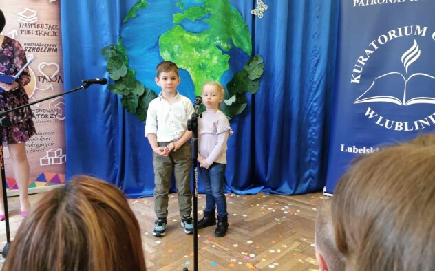 dwóch chłopców stoi przed mikrofonem