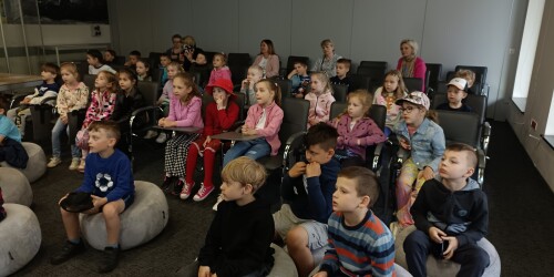 Dzieci słuchające opowiadania w sali wykładowej