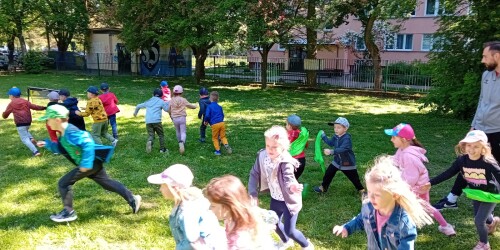 Dzieci biegające po ogródku przedszkolnym