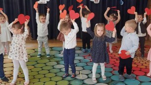 Dzieci z czerwonymi sercami z papieru